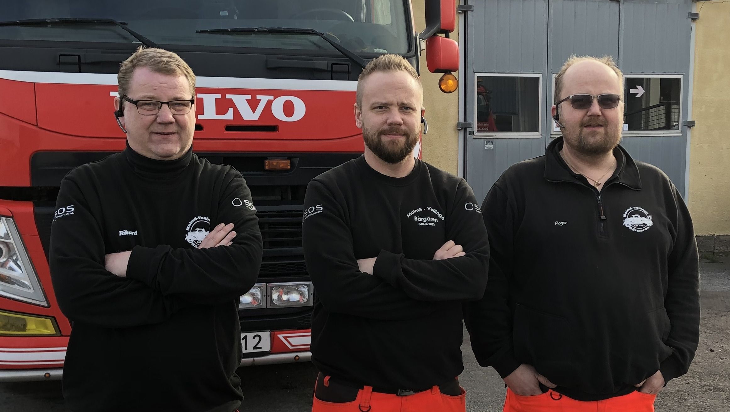 tre bärgare framför bärgarfordon